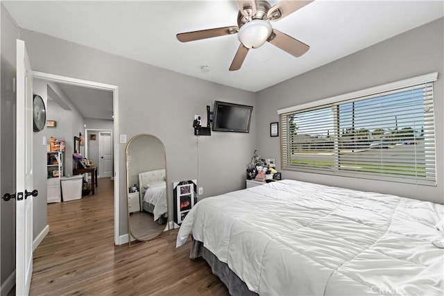 bedroom featuring wood finished floors, baseboards, and ceiling fan