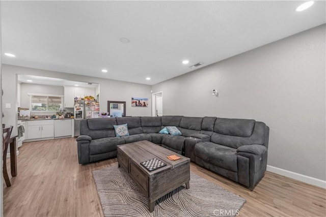 living area with light wood finished floors and recessed lighting