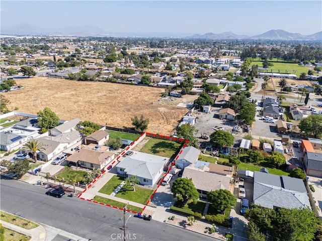 aerial overview of property's location with a mountainous background, property boundaries highlighted, and nearby suburban area