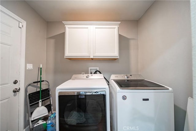 laundry area featuring washing machine and clothes dryer and cabinet space