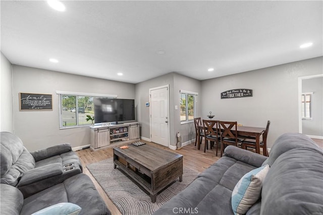 living room with recessed lighting, light wood-type flooring, and baseboards