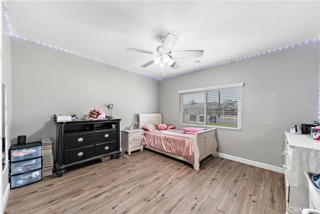 bedroom with light wood-style flooring, baseboards, and ceiling fan