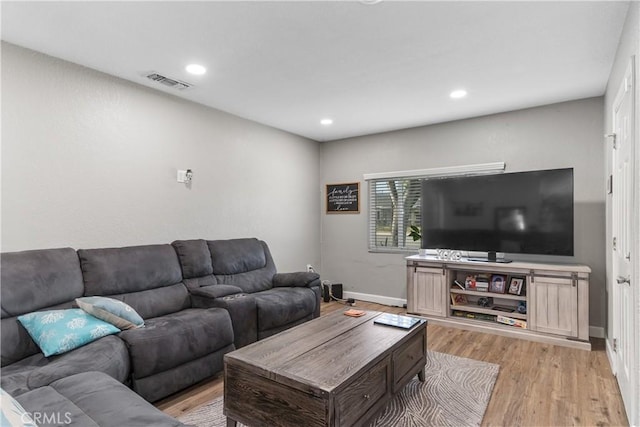 living room with baseboards, light wood-type flooring, and recessed lighting