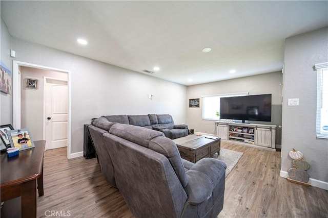 living room featuring wood finished floors, baseboards, and recessed lighting
