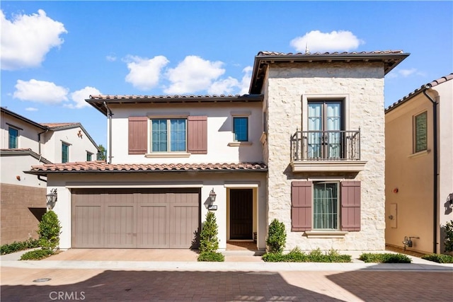 mediterranean / spanish-style house featuring stone siding, a tile roof, and a balcony