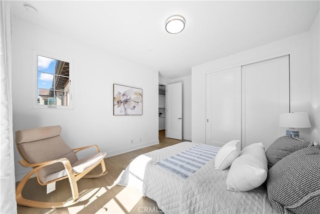 bedroom with baseboards, a closet, and wood finished floors