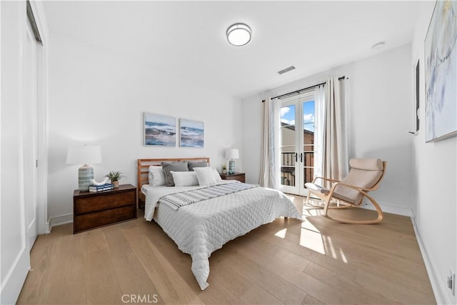 bedroom featuring access to outside, baseboards, visible vents, and light wood-style floors