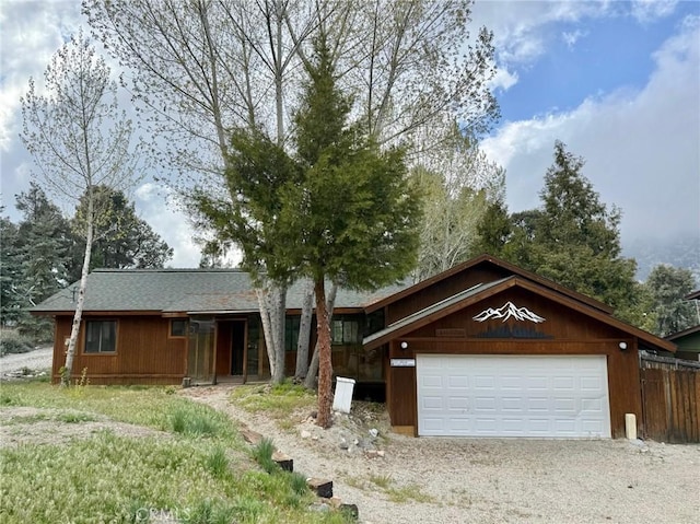 14721 Voltaire Dr, Pine Mountain Club, CA 93225 - view of front facade featuring an attached garage, fence, and gravel driveway