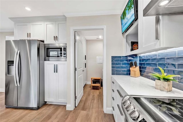 6702 Sun Dr Unit C, Huntington Beach, CA 92647 - kitchen featuring crown molding, wall chimney exhaust hood, tasteful backsplash, light wood finished floors, and stainless steel appliances