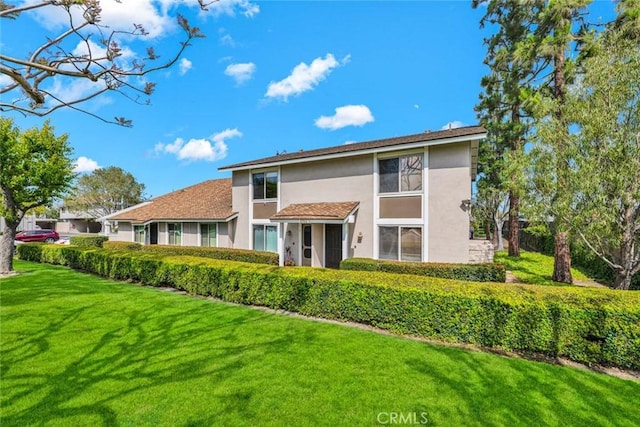 6702 Sun Dr Unit C, Huntington Beach, CA 92647 - rear view of house featuring stucco siding and a yard