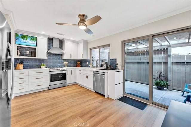 6702 Sun Dr Unit C, Huntington Beach, CA 92647 - kitchen with crown molding, wall chimney range hood, light wood-type flooring, tasteful backsplash, and stainless steel appliances