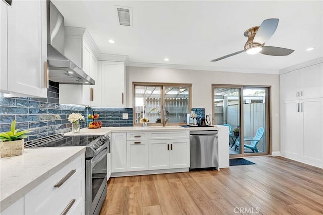 6702 Sun Dr Unit C, Huntington Beach, CA 92647 - kitchen featuring wall chimney range hood, plenty of natural light, stainless steel appliances, and crown molding