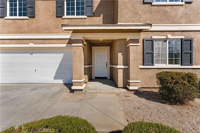 42570 72nd St W, Lancaster, CA 93536 - view of exterior entry featuring concrete driveway, an attached garage, and stucco siding