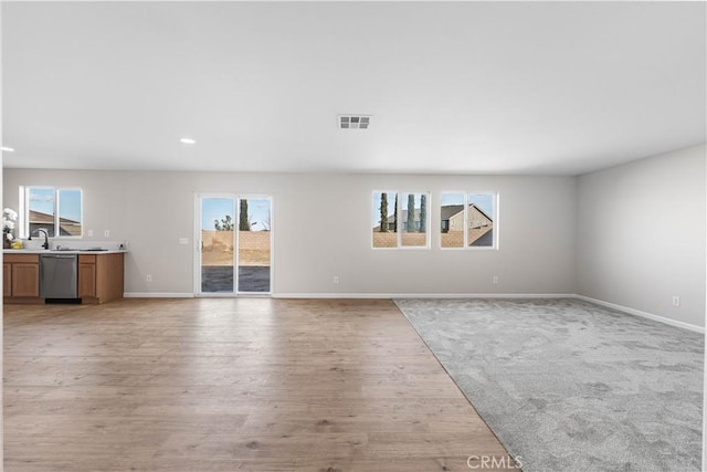 42570 72nd St W, Lancaster, CA 93536 - unfurnished living room with visible vents, light wood finished floors, baseboards, and a healthy amount of sunlight