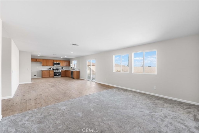 42570 72nd St W, Lancaster, CA 93536 - unfurnished living room with recessed lighting, baseboards, visible vents, and light carpet