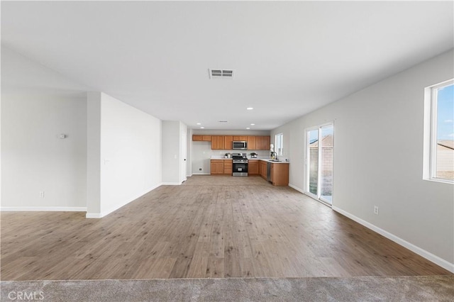 42570 72nd St W, Lancaster, CA 93536 - unfurnished living room featuring baseboards, visible vents, a wealth of natural light, and light wood-style flooring