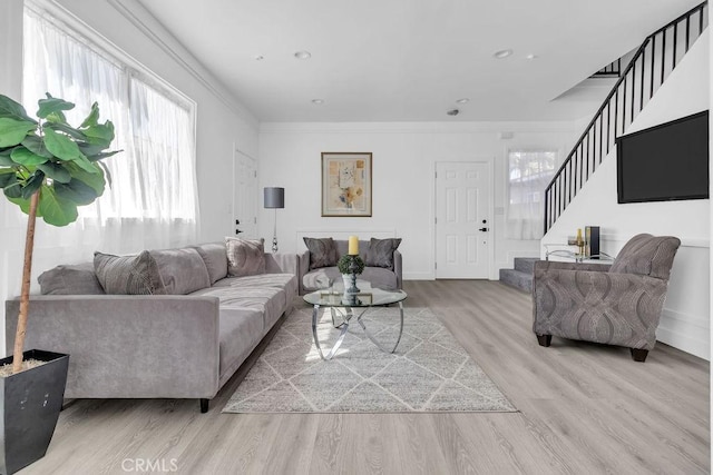 living area featuring crown molding, stairs, wood finished floors, baseboards, and recessed lighting