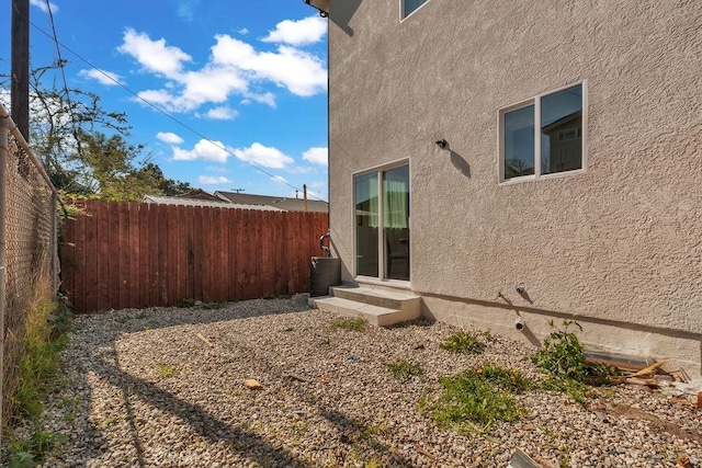 view of side of property with fence and stucco siding