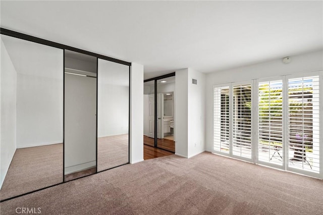 unfurnished bedroom featuring visible vents and carpet flooring