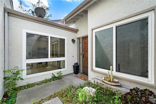entrance to property featuring stucco siding