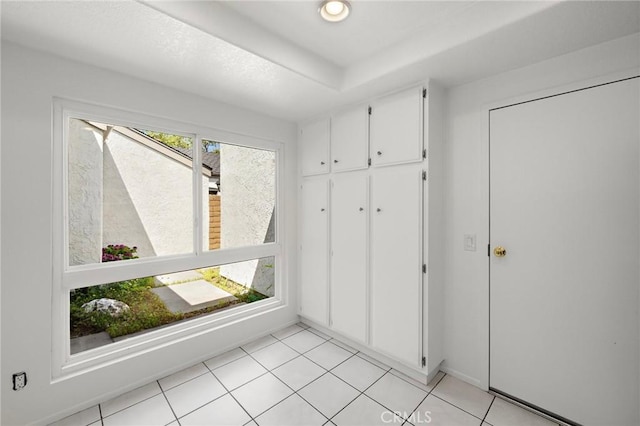 interior space with baseboards and light tile patterned floors