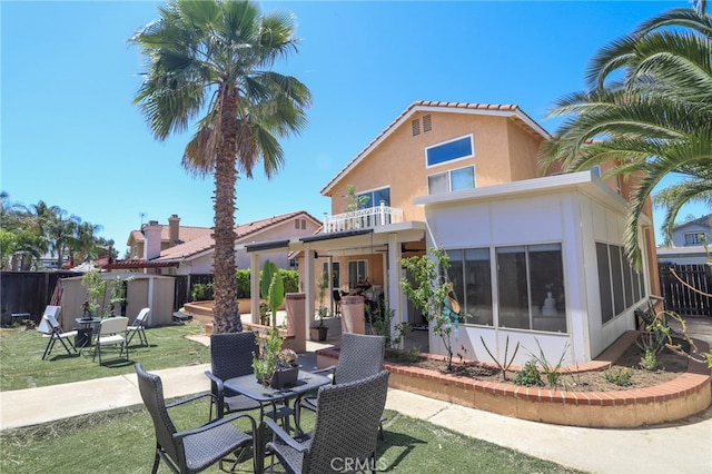 3667 Sonoma Oaks Ave, Perris, CA 92571 - rear view of house with a patio area, fence, a balcony, outdoor dining space, and stucco siding