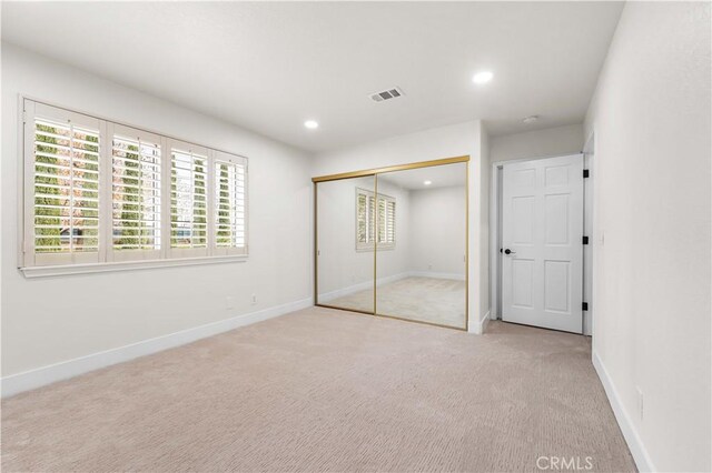 unfurnished bedroom featuring visible vents, baseboards, a closet, carpet flooring, and recessed lighting