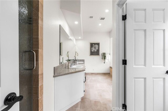 bathroom featuring double vanity, visible vents, a sink, tile patterned floors, and tiled shower