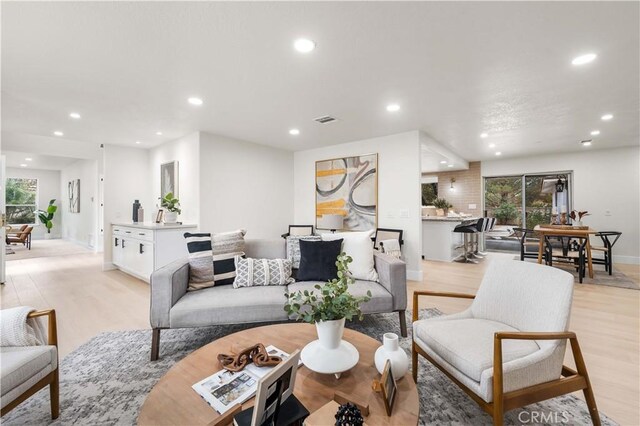 living area featuring baseboards, recessed lighting, light wood-style flooring, and visible vents