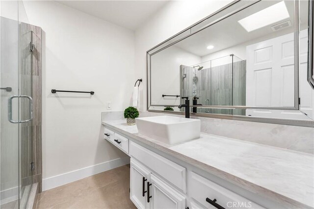 bathroom featuring vanity, baseboards, a stall shower, and visible vents