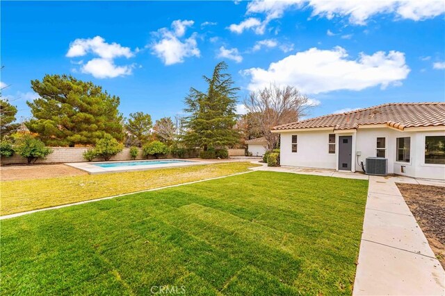 view of yard with central air condition unit, a fenced in pool, a fenced backyard, and a patio