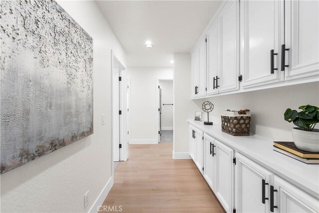 corridor featuring recessed lighting, baseboards, and light wood-type flooring