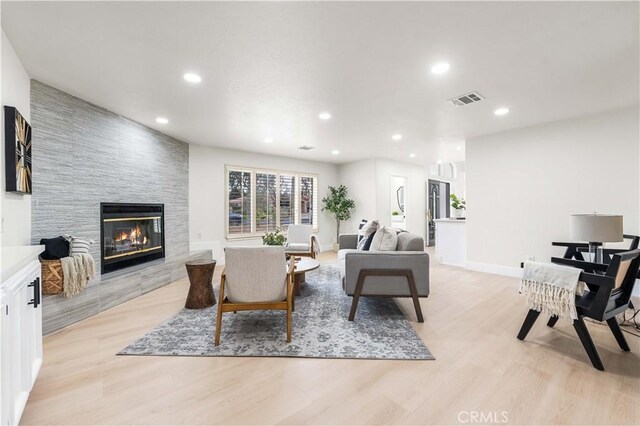 living area featuring visible vents, recessed lighting, light wood-style flooring, and a fireplace
