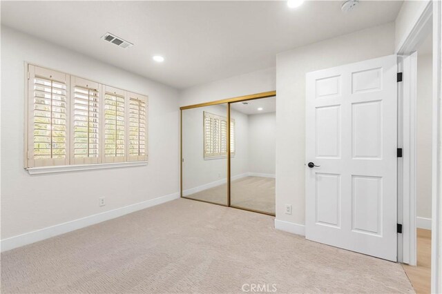 unfurnished bedroom featuring visible vents, a closet, baseboards, recessed lighting, and carpet