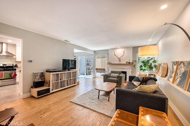 30735 Calle Resplendor, San Juan Capistrano, CA 92675 - living area with light wood-style floors, a brick fireplace, a wealth of natural light, and visible vents
