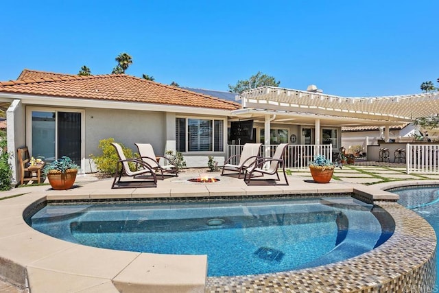 back of house featuring solar panels, a tile roof, a patio area, a fire pit, and stucco siding