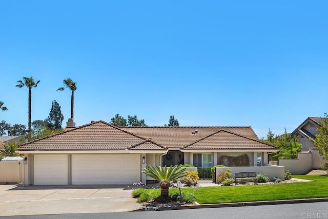 view of front of house with a garage, fence, driveway, and a tile roof