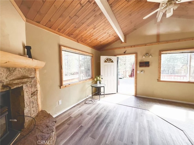 unfurnished living room featuring ceiling fan, beam ceiling, wood finished floors, wooden ceiling, and baseboards