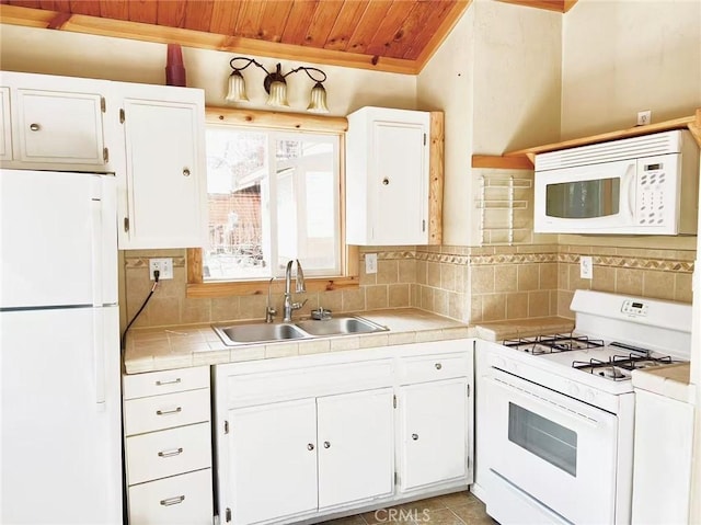 kitchen featuring white cabinets, a sink, white appliances, tile counters, and wood ceiling