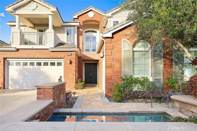 18345 Watson Way, Yorba Linda, CA 92886 - view of front of house featuring a garage, concrete driveway, brick siding, and a balcony