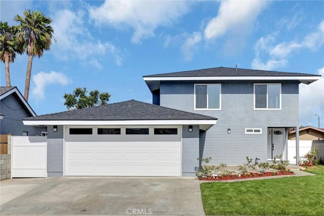 view of front of house with fence, an attached garage, driveway, and a front yard
