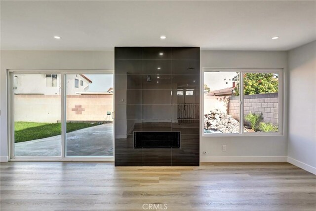 unfurnished living room featuring recessed lighting, baseboards, and wood finished floors