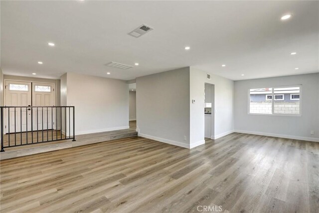 spare room with recessed lighting, wood finished floors, and visible vents