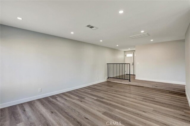 unfurnished room featuring baseboards, recessed lighting, wood finished floors, and visible vents
