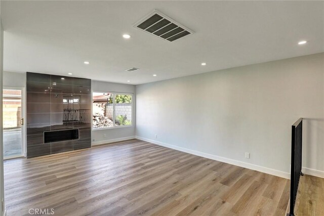 unfurnished living room featuring recessed lighting, baseboards, visible vents, and light wood-style floors