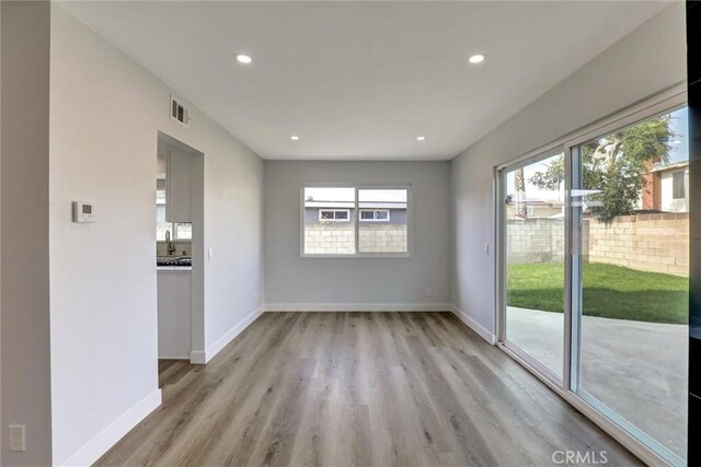 unfurnished dining area featuring light wood-type flooring, recessed lighting, and baseboards