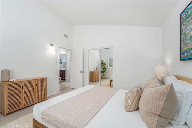 bedroom featuring high vaulted ceiling, a closet, and visible vents