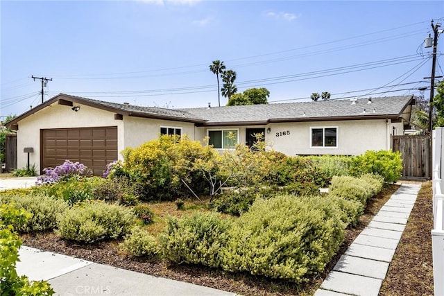 ranch-style house featuring fence, stucco siding, and a garage