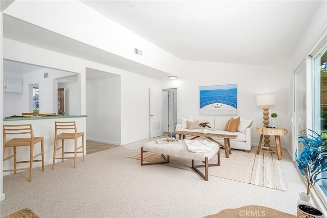 living area with carpet, vaulted ceiling, and visible vents