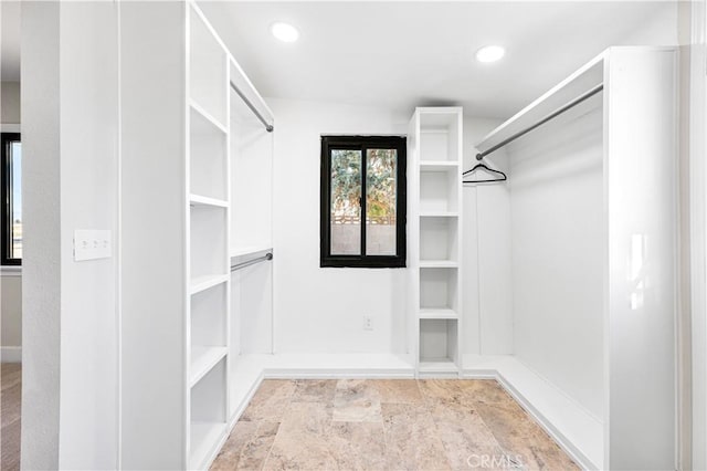 spacious closet featuring stone finish floor